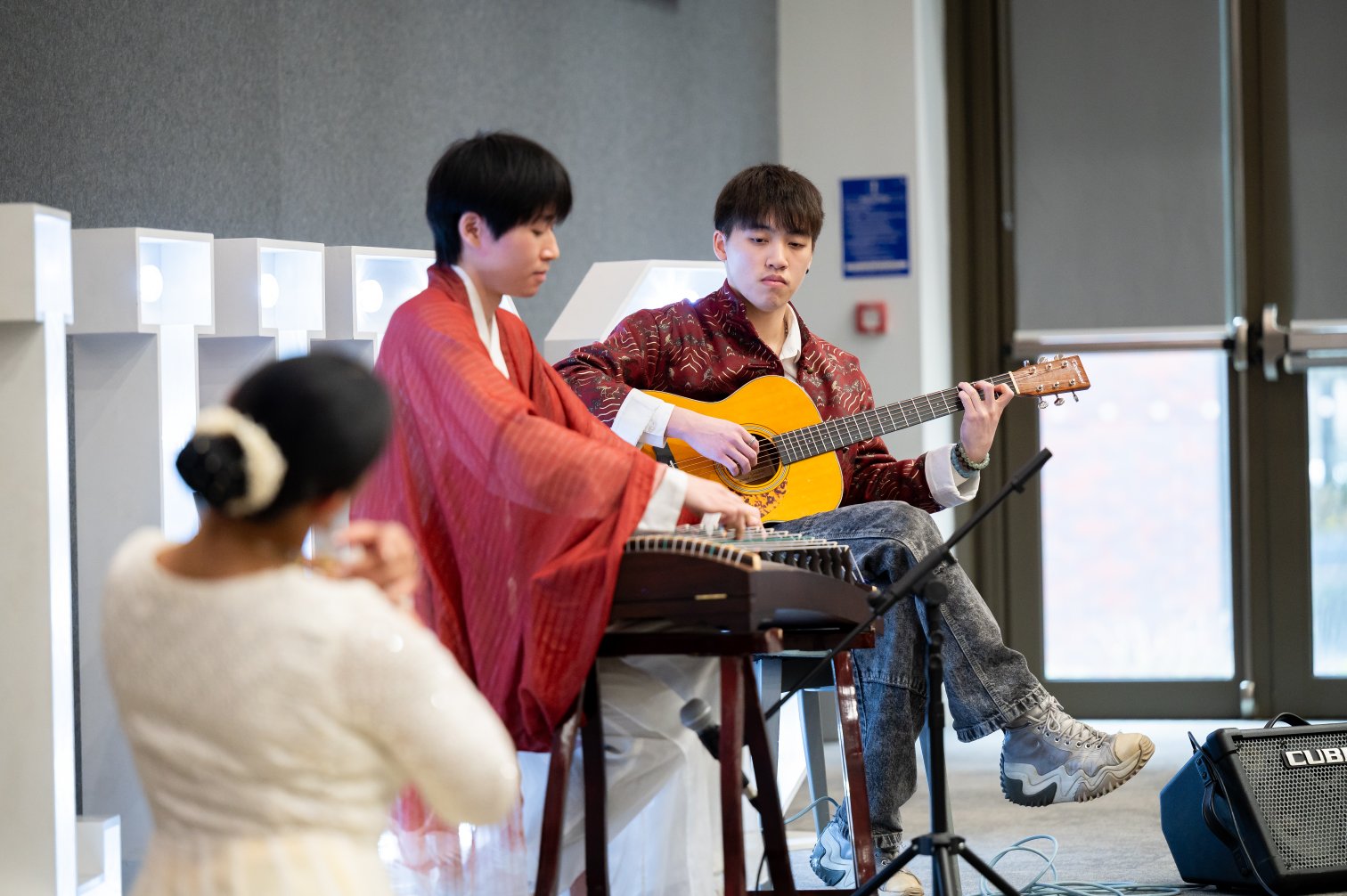 Musicians performing guzheng, dizi, and guitar at the Wellbeing Hub fusion performance